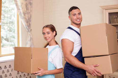 Professional movers carrying furniture through a central London apartment building